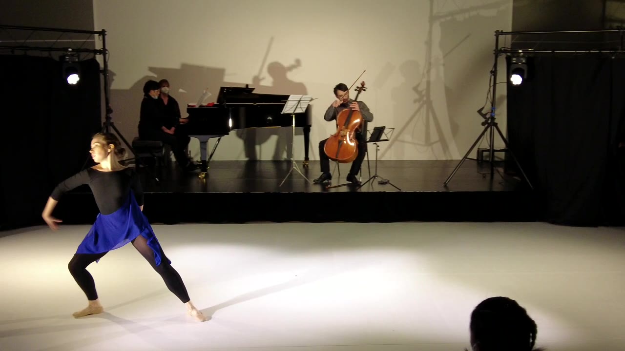 Tänzerin im tiefen Ausfallschritt, dahinter der Cellist
