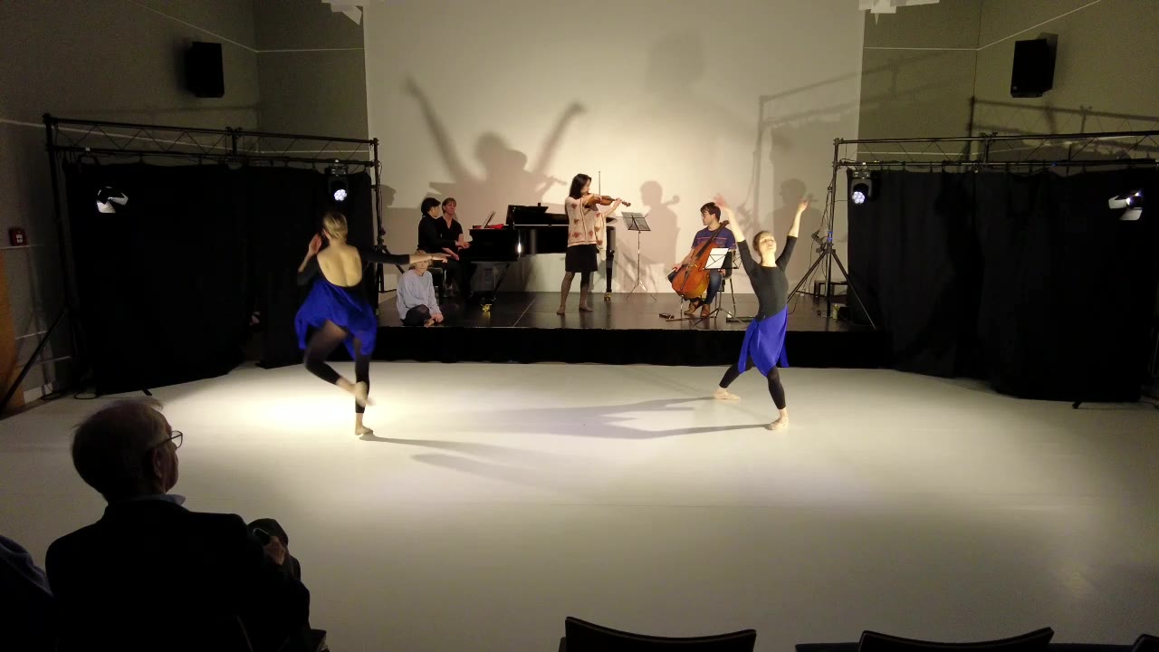 Zwei Tänzerinnen und ihre Schatten an der Wand über den Musikern